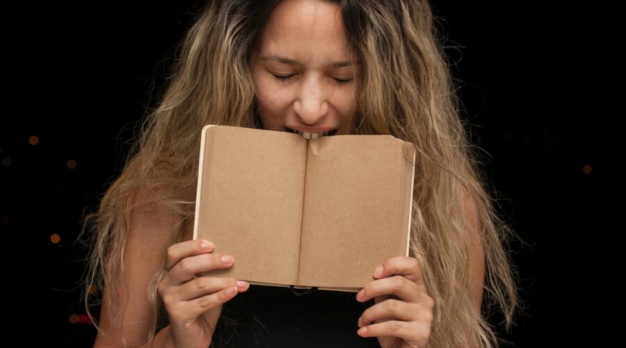 woman covering her face with brown book