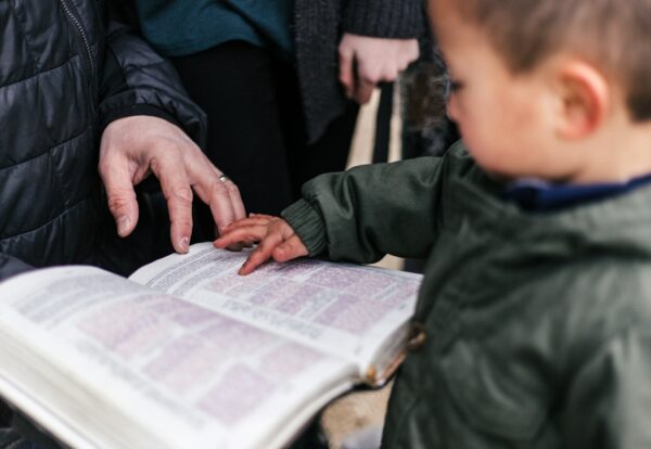 boy touching page of book