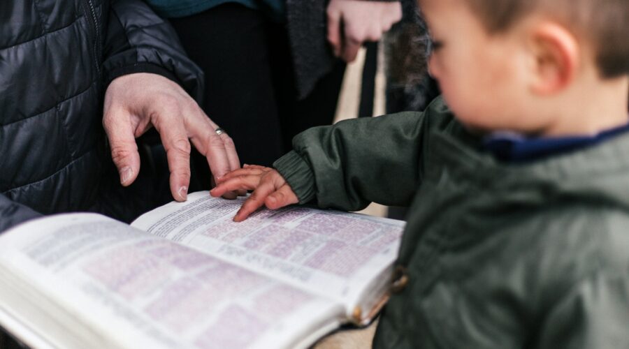 boy touching page of book