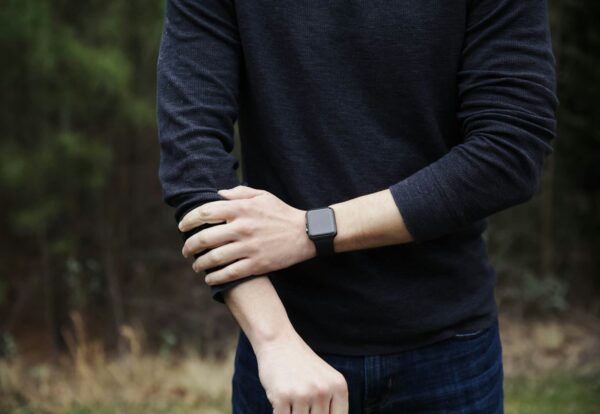 a man in a black shirt is holding his hands together