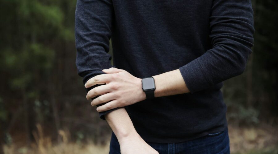 a man in a black shirt is holding his hands together