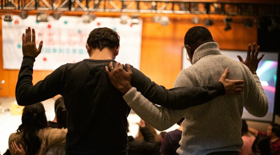 two men holding ear others hand